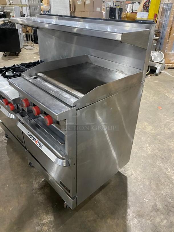 Therma-Tek stainless steel 6 burner range with flat griddle, double oven combo, built-in broiler, and salamander shelf on casters.