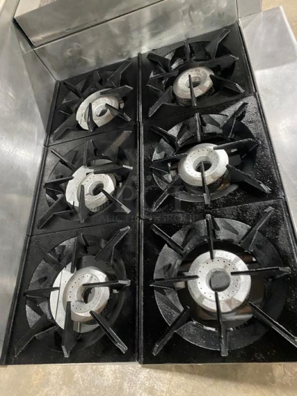 Therma-Tek 6-burner stainless steel range with raised flat griddle, double oven, broiler, cheese melter, and overhead shelf.