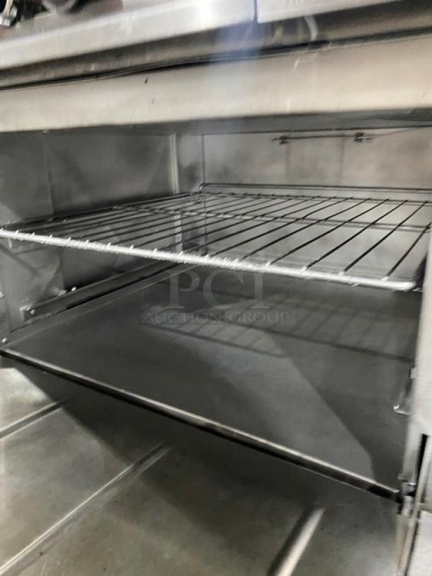 Therma-Tek stainless steel 6 burner range with double oven, broiler, overhead salamander shelf, and wired racks.