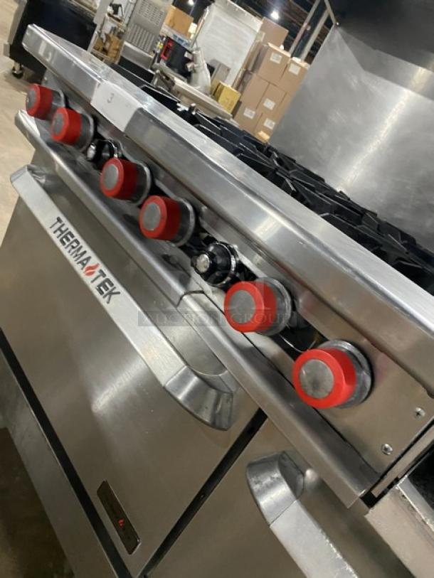 Therma-Tek commercial stainless steel range with 6 burners, raised griddle, double oven, broiler, casters, and salamander shelf.