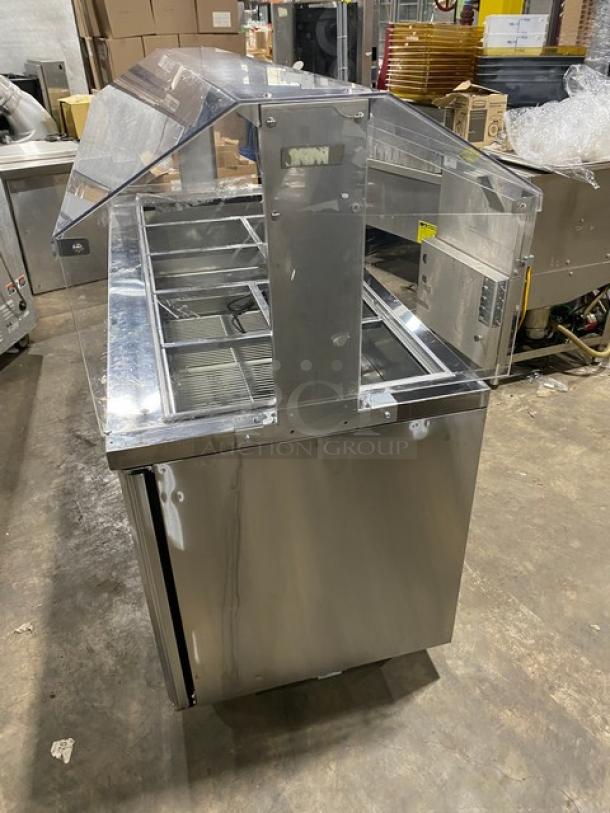 Turbo Air JBT-72-N stainless steel 3-door cold food display table with sneeze guard, poly wire racks, on casters.