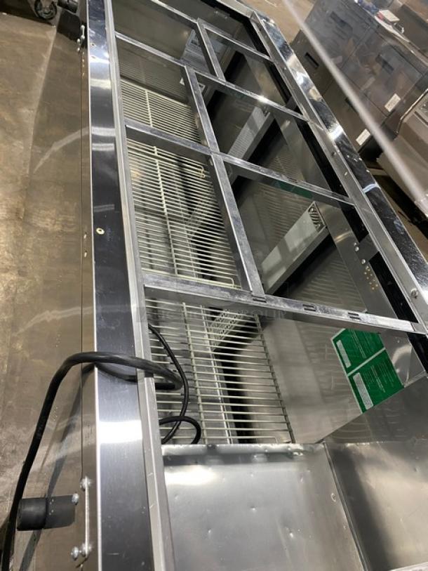 Turbo Air JBT-72-N 3-door stainless steel refrigerated salad bar with sneeze guard, poly-coated wire racks, on casters.