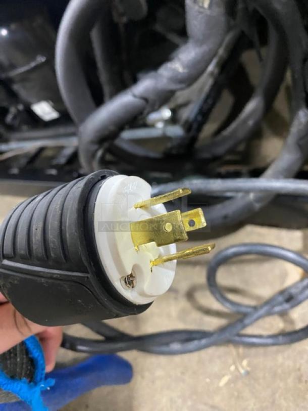 Close-up of a power plug for True TS-72F commercial freezer, showing gold prongs and black grip.