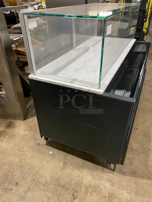 Structural Concepts SBZ6652DR black refrigerated merchandiser with multi-level display, top glass showcase, 220V, on legs.