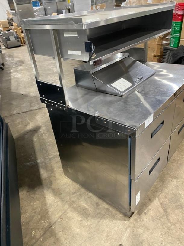 Delfield stainless steel 4-drawer refrigerated prep table with bain marie style, overhead storage, and enclosed compartment.