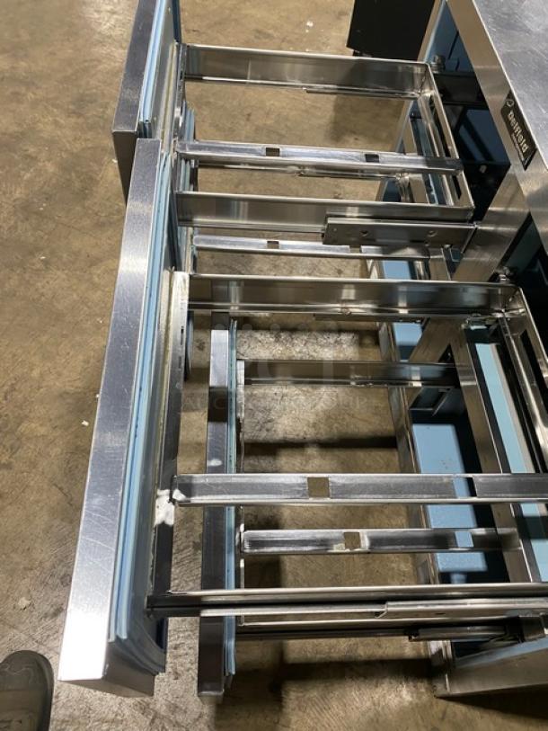 Delfield commercial stainless steel 4 drawer refrigerated prep table with overhead storage, open view, shows sturdy construction.