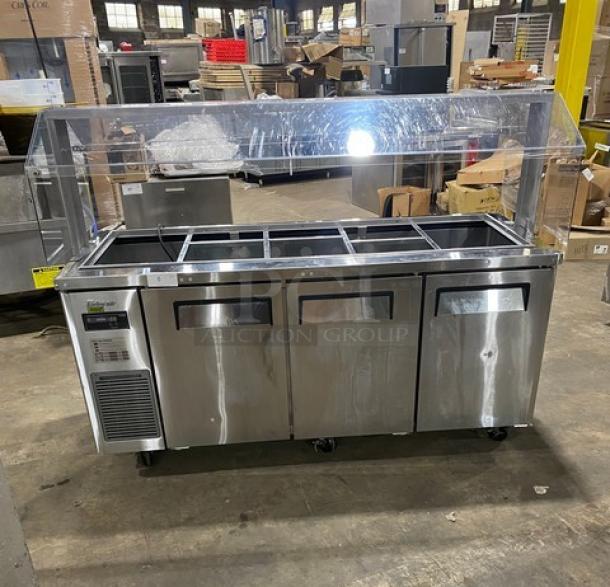 Turbo Air JBT72N 3-door stainless steel refrigerated buffet table with sneeze guard and poly-coated wire racks on casters.