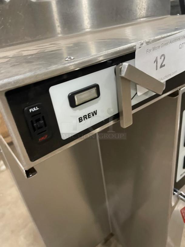 Fetco CBS-52H15 stainless steel twin coffee brewer with hot water dispenser, electric, 240V, 1 Phase, on legs.