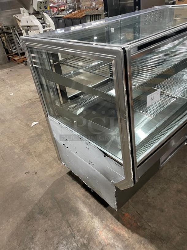 Leader Commercial Stainless Steel 57" Refrigerated Bakery Display Case, Model CBK57. Features adjustable wire racks, straight glass design, 115V 1 Phase. Some wear visible.