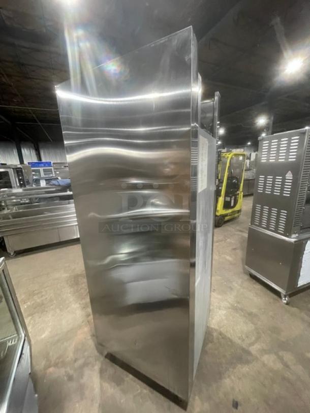 Traulsen RLT132WUT-FHS single door stainless steel freezer, Energy Star certified, on legs, side view in warehouse setting.