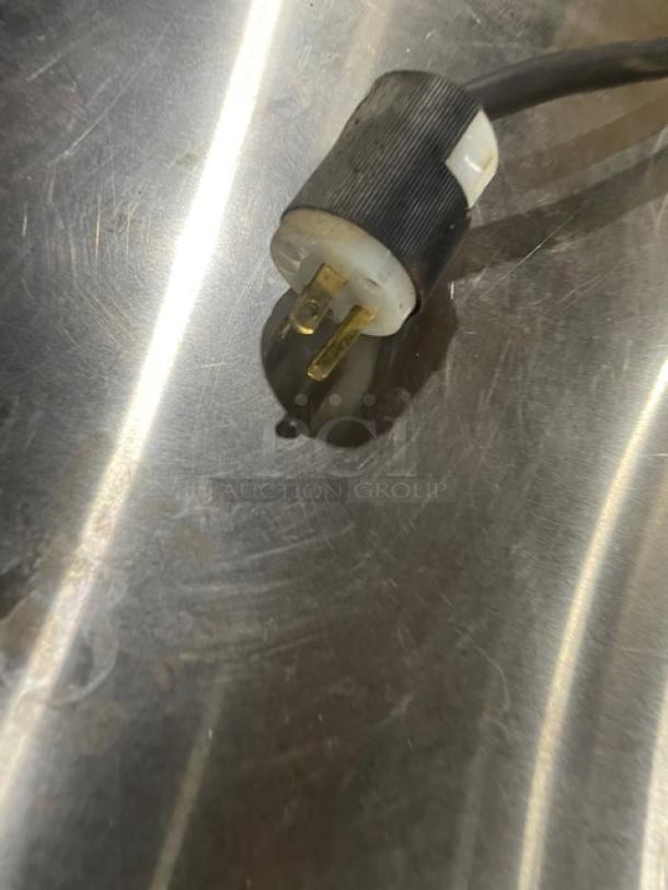 Close-up of an electric plug on a stainless steel surface, part of the Asber AEPOE26 pizza deck oven.