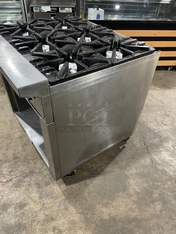 U.S. Range commercial stainless steel 6-burner natural gas range with enclosed cabinet base on casters, in used condition.