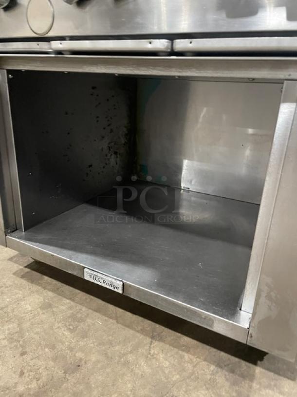 U.S. Range 6-burner stainless steel commercial range with natural gas power, enclosed cabinet base, and casters.