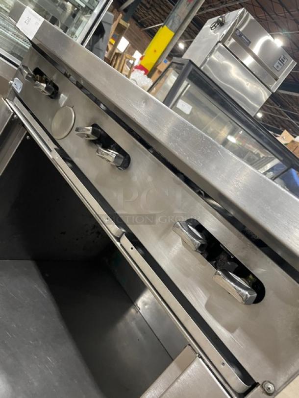 U.S. Range stainless steel 6-burner natural gas range with enclosed cabinet base, on casters. Good condition.