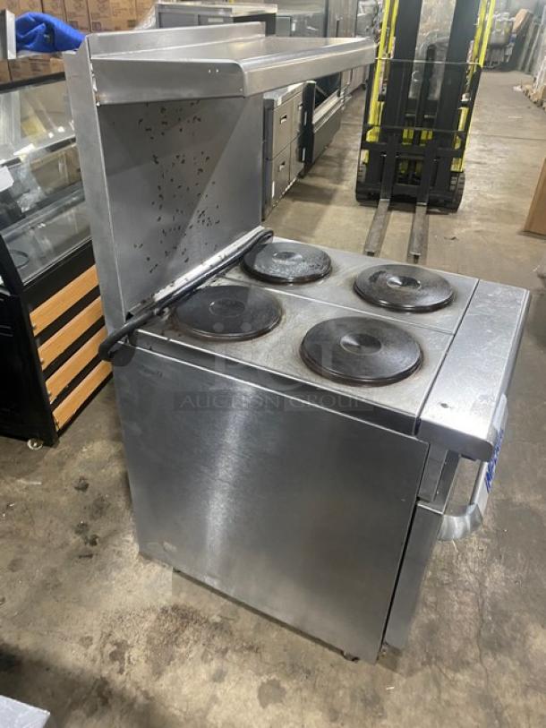 Imperial commercial stainless steel electric 4-burner hot plate range/oven combo with backsplash, overhead salamander shelf, and wire oven rack.