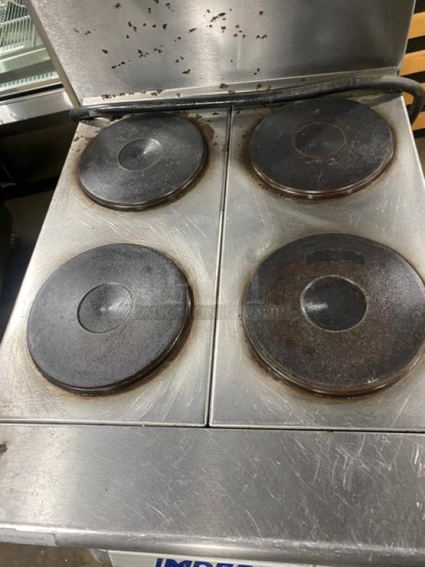 Imperial stainless steel electric 4-burner hot plate range/oven combo with backsplash, overhead salamander shelf, and wire oven rack.