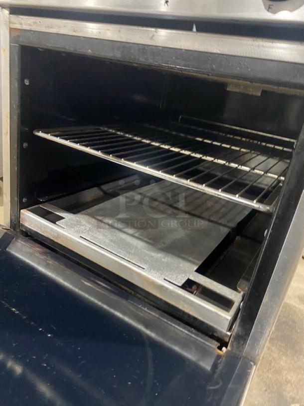 Imperial stainless steel electric 4-burner range/oven combo with back splash, salamander shelf, and wire oven rack.