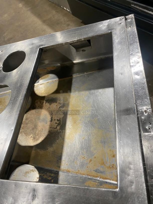 Commercial stainless steel cabinet with double shelf, drop-in adapter plate, and drain hole. Visible wear on surface.