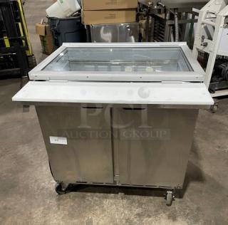 Beverage-Air stainless steel 2-door refrigerated prep table with glass top and cutting board. Model SPE36HC-15M-STL on casters.