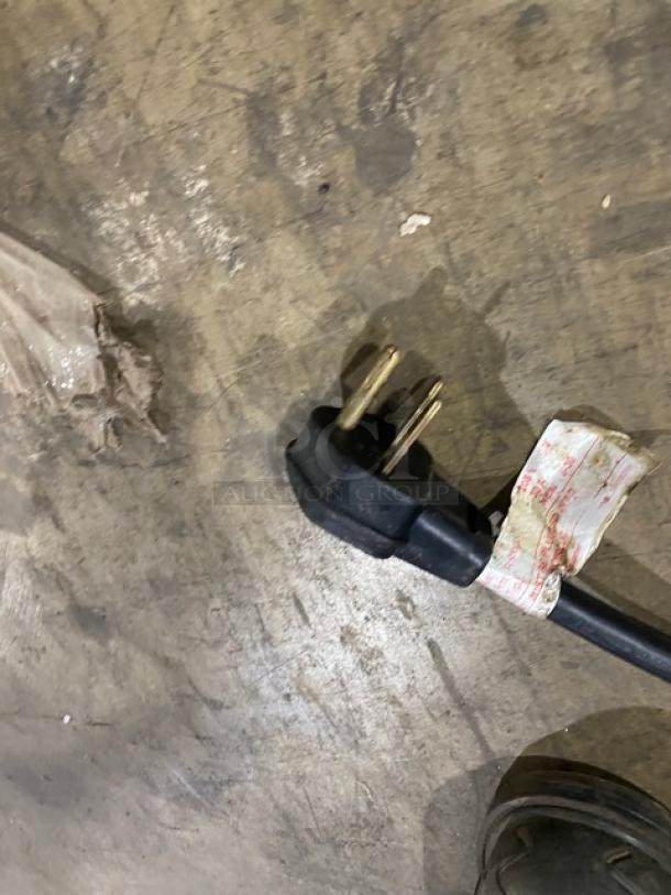 Three-prong plug with a worn label, part of Amana Model RC30S2 Commercial Microwave, 208/230V electric powered.