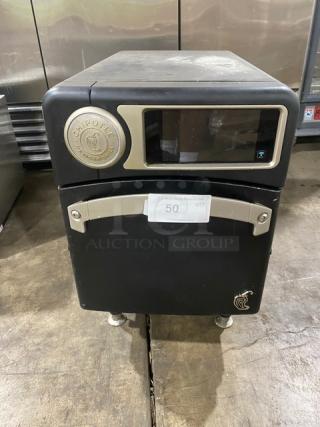 TurboChef NGO 2021 ventless rapid cook oven, black, Chipotle style, electric, countertop model with crank bar, on legs.