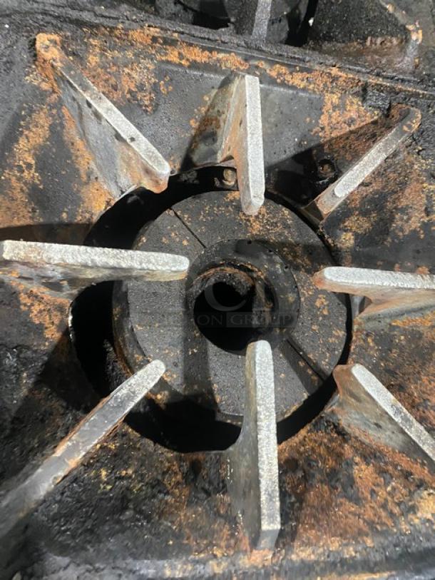 Close-up of a burner from a Bakers Pride 10-Burner Range, showing rust and wear. Part of model 60BP10BS26N.