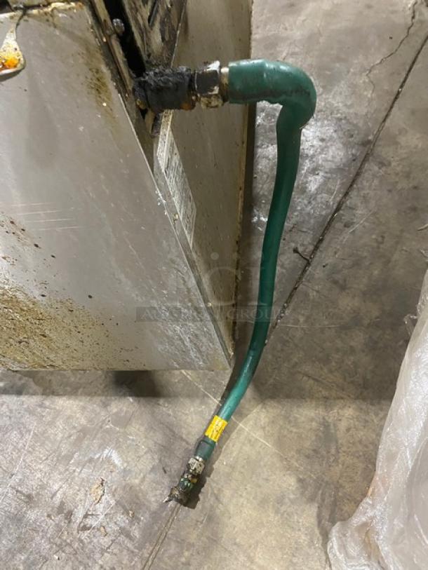 Bakers Pride 60BP10BS26N gas connection hose, attached to the stainless steel body of a commercial range.
