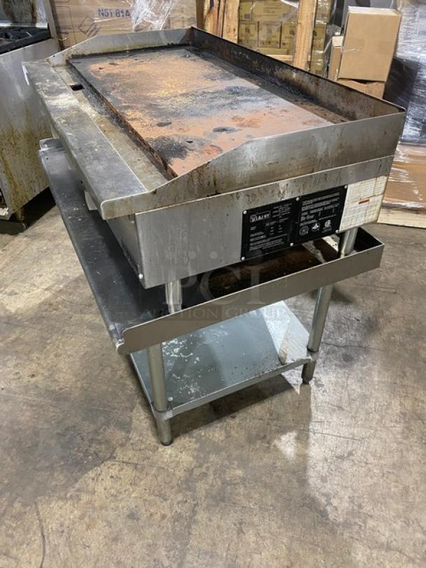 L&J JRMG48NG stainless steel natural gas countertop flat griddle with undershelf, legs, back and side splash, gas hose connected.
