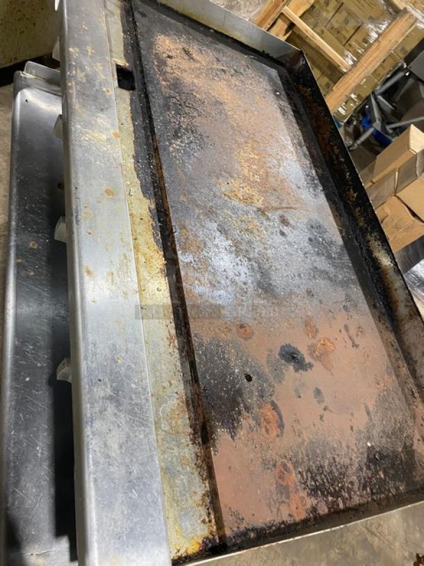 L&J JRMG48NG stainless steel flat griddle, natural gas, with standalone undershelf, back and side splash, and gas hose. Signs of wear.