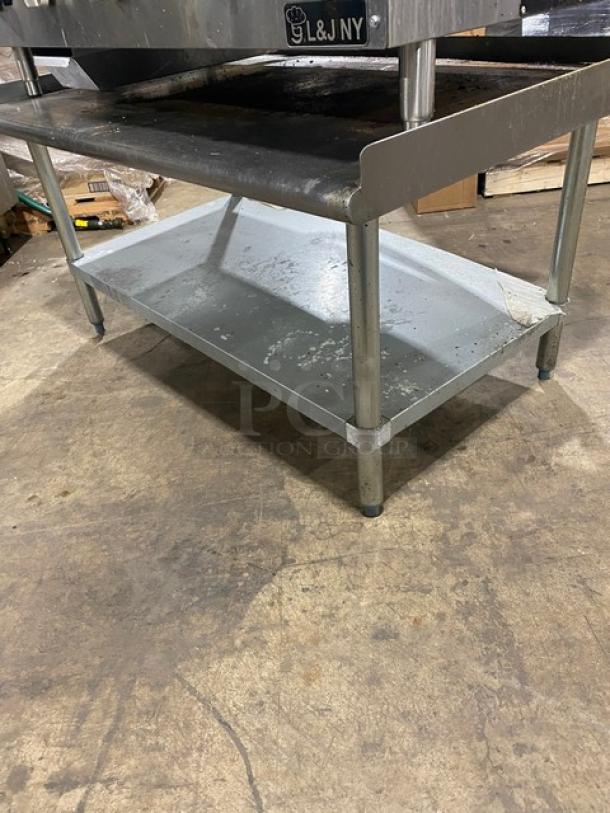 L&J JRMG-48NG stainless steel gas griddle with undershelf stand, back and side splash, showing legs; equipment aged.