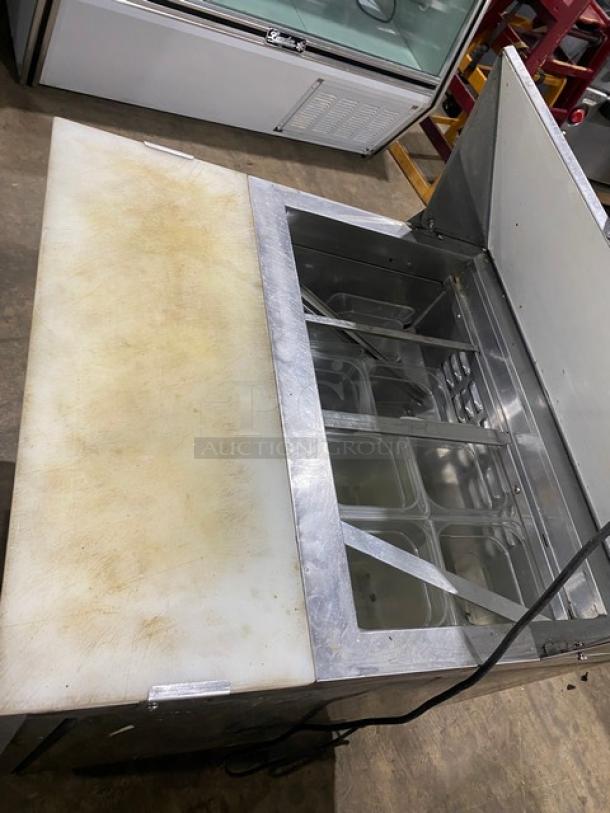 Avantco stainless steel refrigerated bain marie salad prep table with cutting board and wire rack, on casters, 115V.