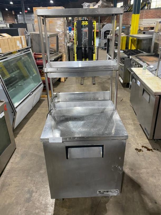 True TWT-27 stainless steel refrigerator, 27" worktop, single door, with backsplash, double overhead shelf, and casters.