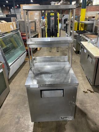 True TWT-27 stainless steel refrigerator, 27" worktop, single door, with backsplash, double overhead shelf, and casters.