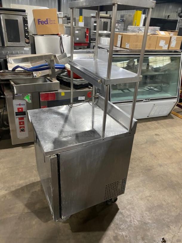 True TWT-27 single door stainless steel worktop refrigerator with backsplash and double overhead shelf, poly-coated wire racks, on casters.