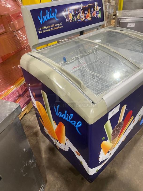 Excelente CF-289 curved top ice cream merchandiser with double sliding glass top, poly coated wire baskets, on casters.
