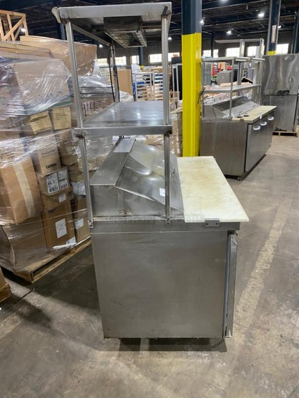 Commercial stainless steel 2-door refrigerated bain marie style prep table with double overhead shelf, Hatco strip warmer, on casters.