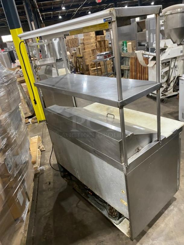 Commercial stainless steel 2-door refrigerated salad/sandwich prep table with dual overhead shelf, Hatco strip warmer, on casters.