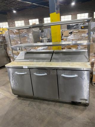 Kool-It KSP72 refrigerated prep table, stainless steel, 3 doors, with cutting board, double shelves, and casters.