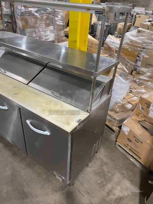 Kool-It KSP72 3-door stainless steel prep table with cutting board, overhead shelves, wire racks, and San Jamar holders on casters.