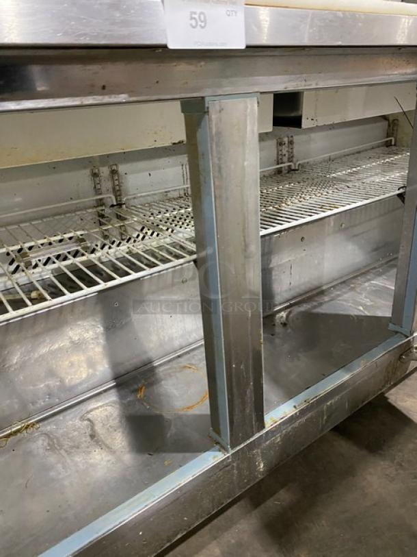 Kool-It KSP72 stainless steel 3-door refrigerated prep table with cutting board, double overhead shelf, wire racks, on casters.