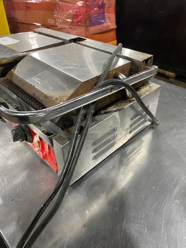 Avantco stainless steel electric countertop dual panini grill with top and bottom grooved grates. Features thermostatic control.