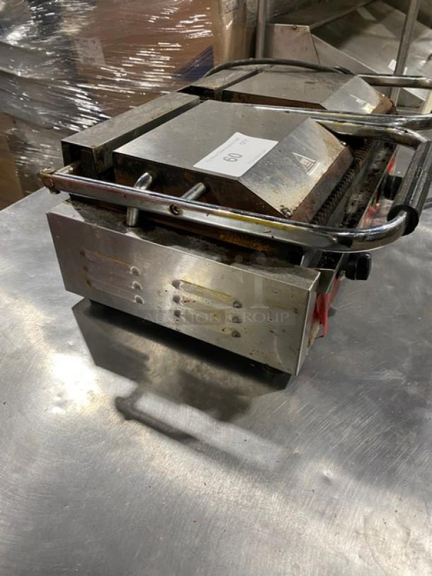 Avantco commercial stainless steel dual panini grill with grooved grates, thermostatic control, on legs. Visible wear.