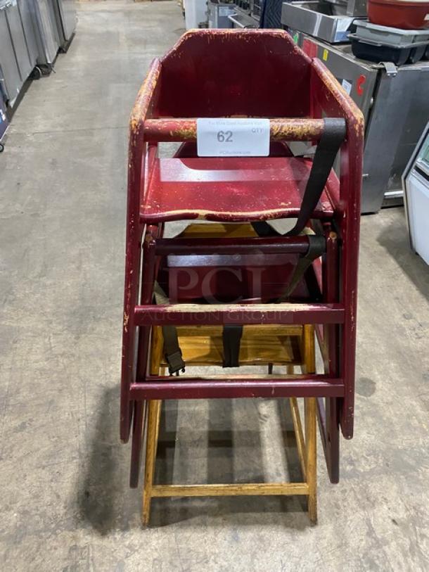 Stackable wooden highchairs with safety buckles, worn condition, multiple units. Auction label on top chair, "62 QTY".