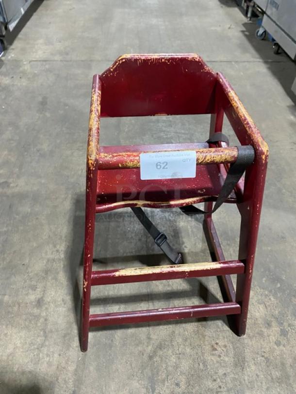 Wooden stackable highchair with safety buckle. Visible wear on edges. Tag reads "62 QTY" indicating available quantity.