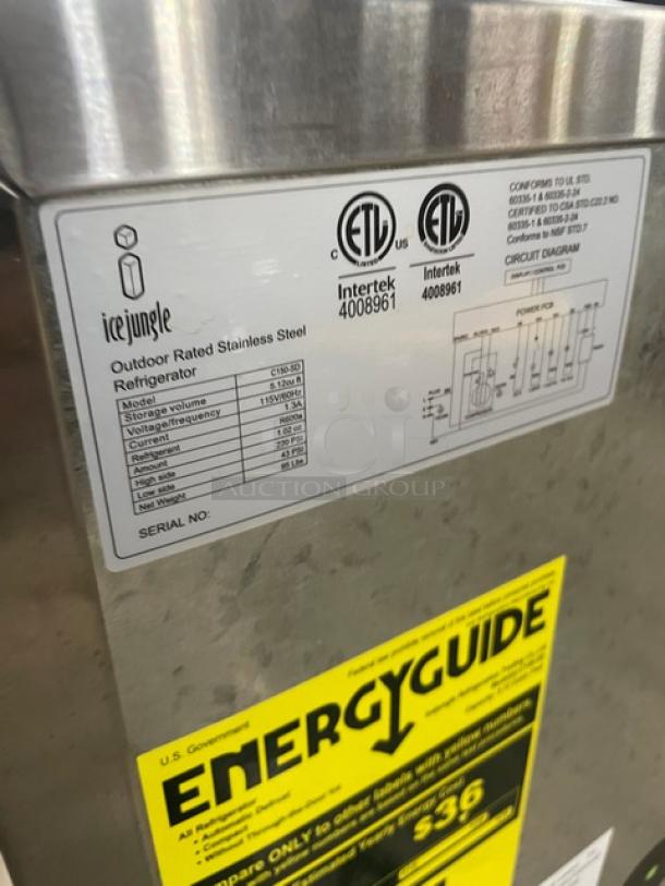 Ice Jungle C150SD 24" outdoor stainless steel refrigerator with poly coated wire rack, featuring ETL certification labels and energy guide.