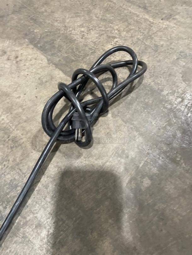 Coiled power cord for Ice Jungle C150SD outdoor refrigerator, shown on a concrete floor.