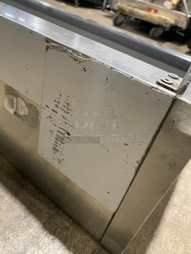 Avantco stainless steel refrigerated countertop prep rail with visible wear. Labels show model specifications and settings.