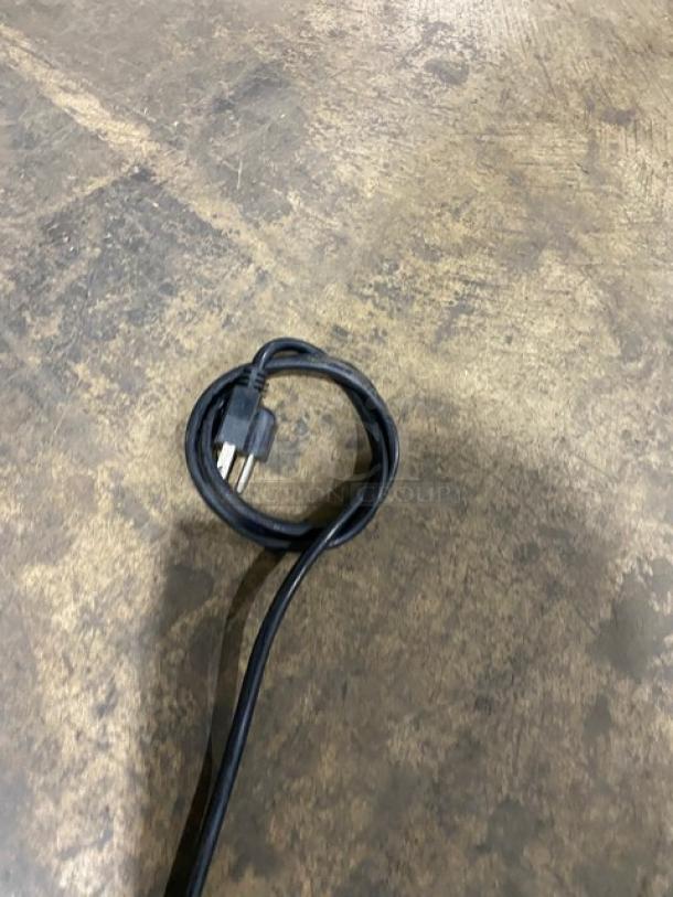 Coiled power cord for Avantco Commercial Stainless Steel Refrigerated Countertop Prep Rail on a concrete floor.