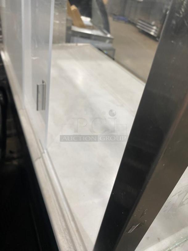 Starbucks style black refrigerated open grab-n-go merchandiser with multi-level shelves and enclosed glass showcase on legs.