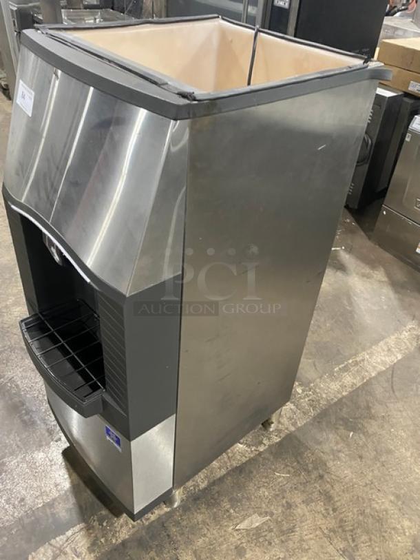 Manitowoc Model SPA160 stainless steel ice dispensing bin with push dispenser, drip tray, 115V, 1 phase, on legs.